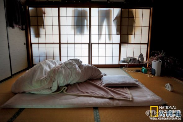 日本人早上起床后通常会把床铺叠好收进橱柜，但3月12日黎明之前在电视新闻发布会发出的疏散指令催促下，他们来不及把家中收拾停当就匆匆撤离。这间卧室位于大熊町，距离出事故的核电站不到5公里。该地区政府官员向东京电力公司发起控诉，称他们没有尽到向居民发出灾难预警的义务。
