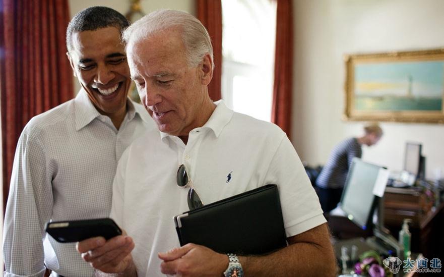 2011年7月16日，奥巴马和搭档拜登一起看iPhone手机的一款应用程序。