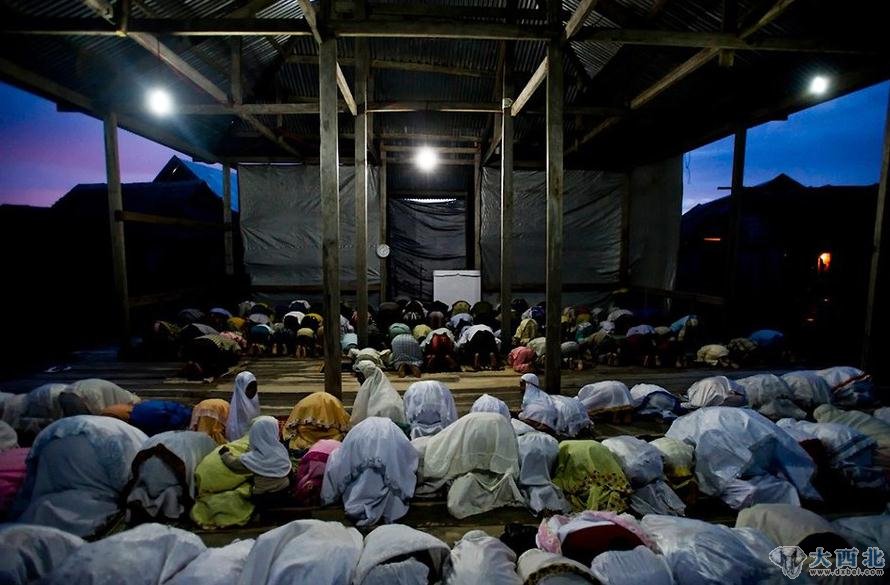 夜幕下的印尼瓦卡托比，巴瑶族的信徒们正在一座海上清真寺祷告。