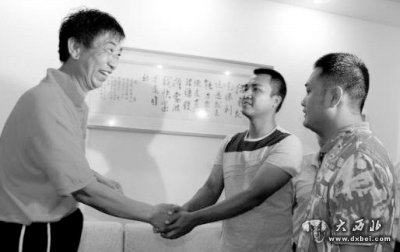      毕国昌（左）与涉事城管队员握手。网络图片